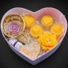 Herzförmige Geschenkbox mit mehreren Bienenwachskerzen und Deko