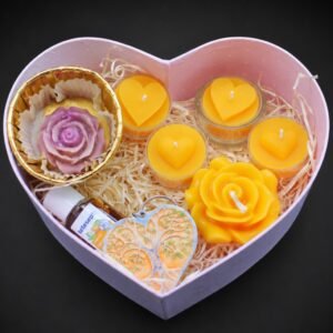 Herzförmige Geschenkbox mit mehreren Bienenwachskerzen und Deko